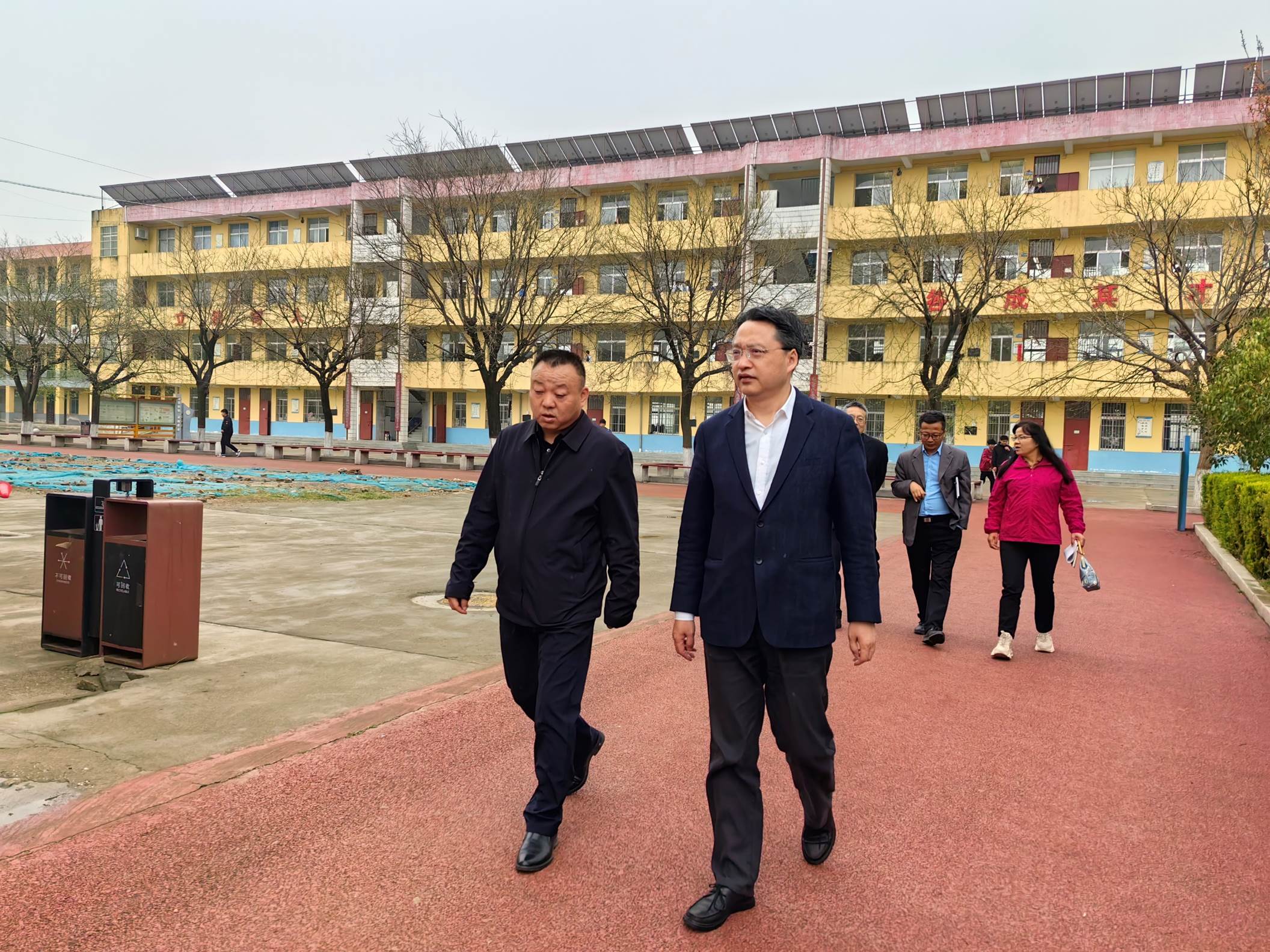 男人们站在建筑前中度可信度描述已自动生成